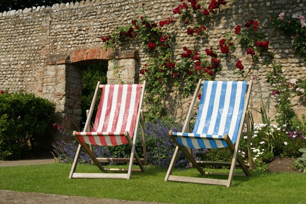Photo of two deck chairs in a garden taken with Sony Alpha A350.Photograph taken with Sony Alpha A350 showcasing vibrant deck chairs and flowers.