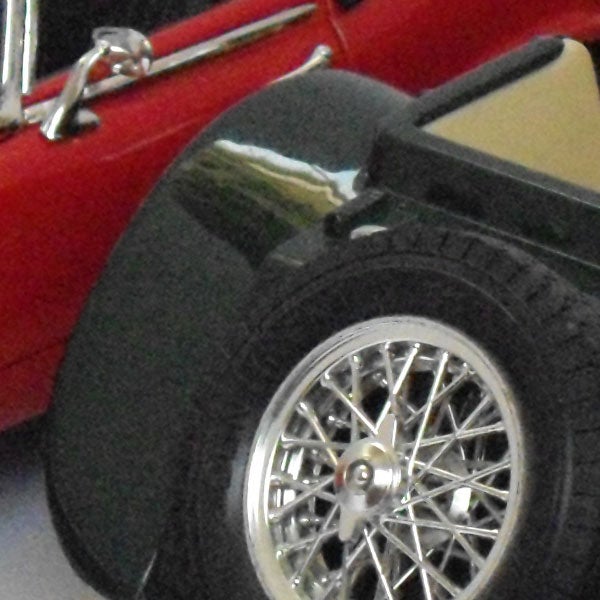 Close-up of a toy car wheel and chrome detailsClose-up of a toy car's wheel and side mirror