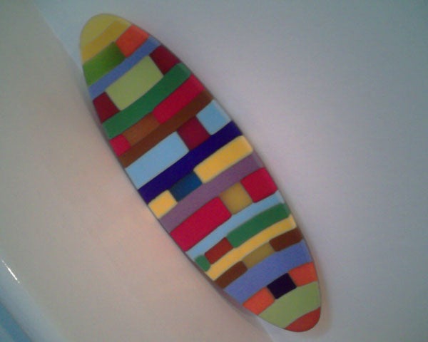 Colorful striped surfboard on a white background