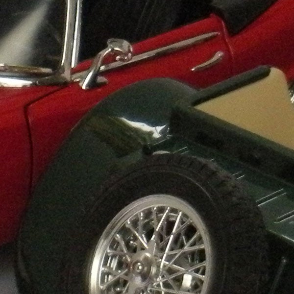 Close-up photo of a vintage car's wheel and side doorClose-up of a red car's door and wheel.