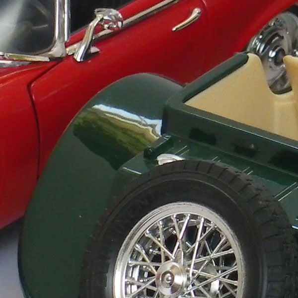 Close-up of toy cars with a focus on the wheels.Close-up of two model cars, a red and a green one.