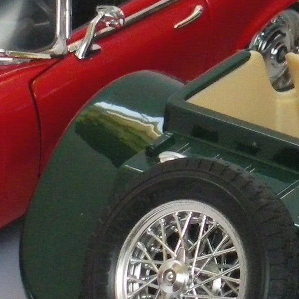 Close-up of a red vintage car and a green toy carClose-up of classic red car and model green vehicle.