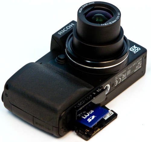 Ricoh GX200 camera with external viewfinder and memory card.