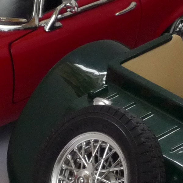 Close-up photo of vintage cars showing detailed craftsmanship.Close-up of classic red and green model cars