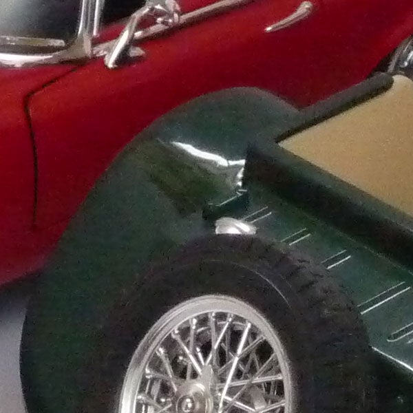Close-up photo of classic red and green toy carsClose-up of vintage cars showcasing camera detail capability.