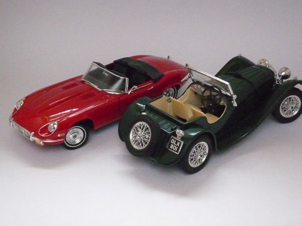 Two model cars, red and green, photographed on gray background.Two model cars captured by Panasonic Lumix DMC-FX35 camera.