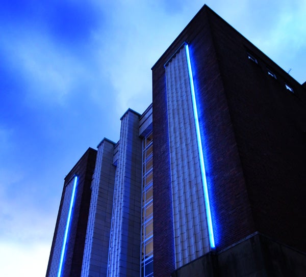 Low-light photo of a building with blue vertical lights.Low-light photo of buildings with blue accent lights