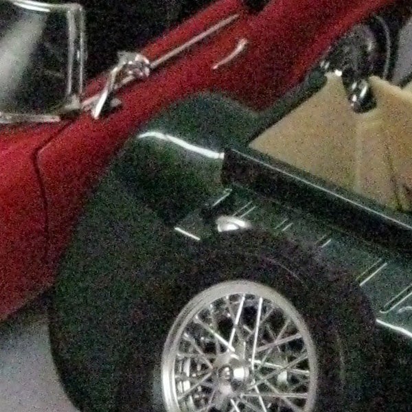 Close-up of a vintage car's wheel and part of the body.Low-light photo of a car's wheel captured with Canon PowerShot A470.