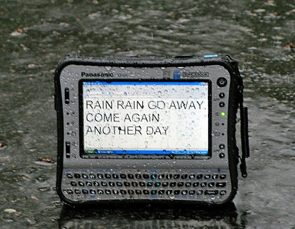 Panasonic ToughBook CF-U1 rugged UMPC in the rain.Panasonic ToughBook CF-U1 in rain displaying text on screen.