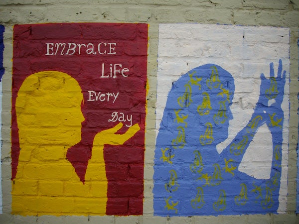 Colorful mural with inspirational message and silhouettes.Mural with inspirational text and colorful silhouettes on a wall.
