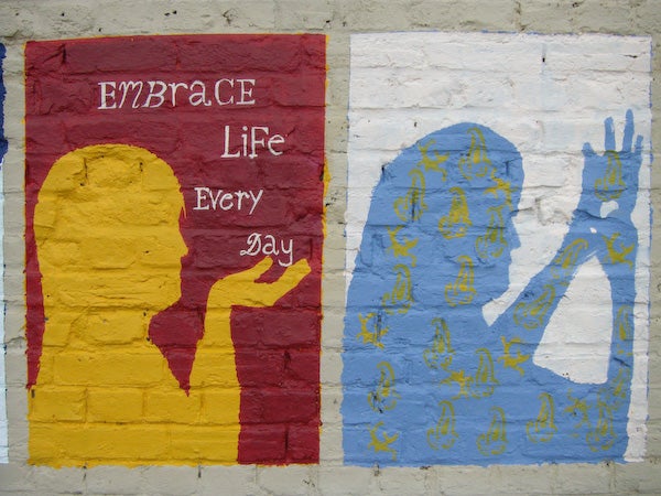 Mural with motivational message and colorful handprints.