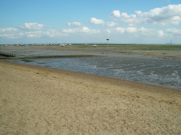 Beach landscape with low tide and boats in the distance.Photo taken with Pentax Optio M50 showing beach and tidal flats.