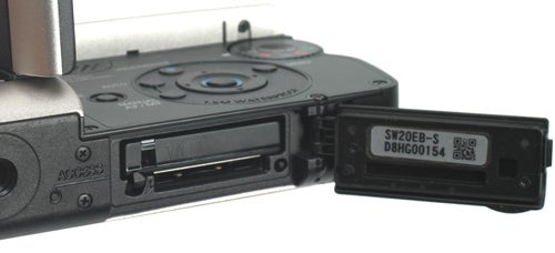 Close-up of Panasonic SDR-SW20 camcorder's open battery compartment.