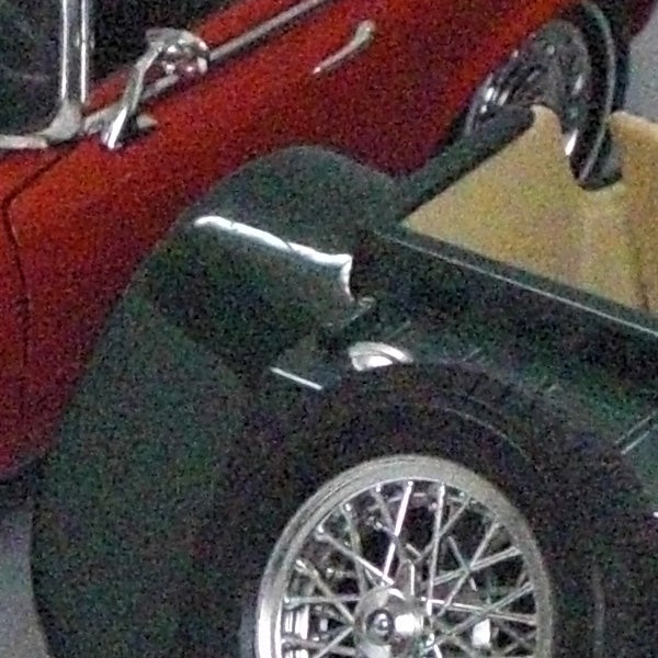 Close-up image of a motorcycle wheel and fender.Close-up of a classic car's wheel and fender