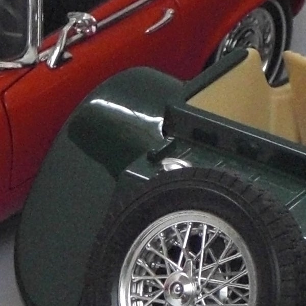 Close-up of a classic car wheel with chrome spokes.Close-up of a vintage car wheel and fender.