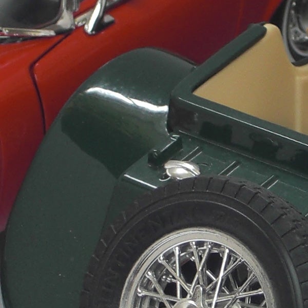 Close-up of a green and red toy car wheels and bodyClose-up of vintage toy cars with focus on wheel detailing