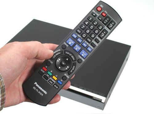 Hand holding Panasonic DMP-BD50 Blu-ray Player remote.