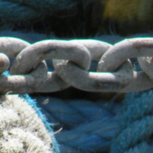 Close-up of a rusty chain with a background.Close-up photo of a rusty chain link over blue background.
