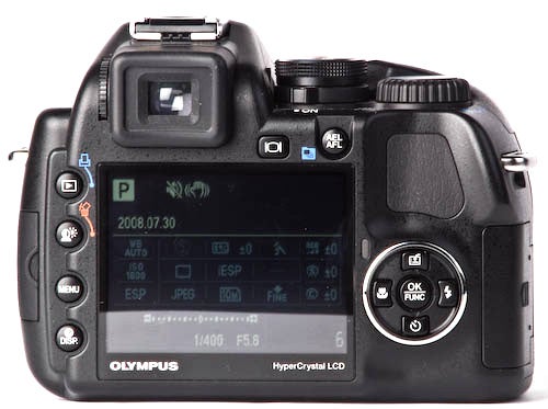 Olympus SP-570 UZ digital camera rear view with LCD display.Olympus SP-570 UZ camera showing LCD screen and controls.