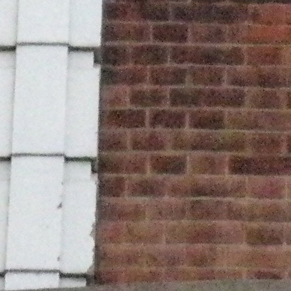 image of a brick wall corner taken by camera.Low-resolution photo of bricks demonstrating camera zoom.