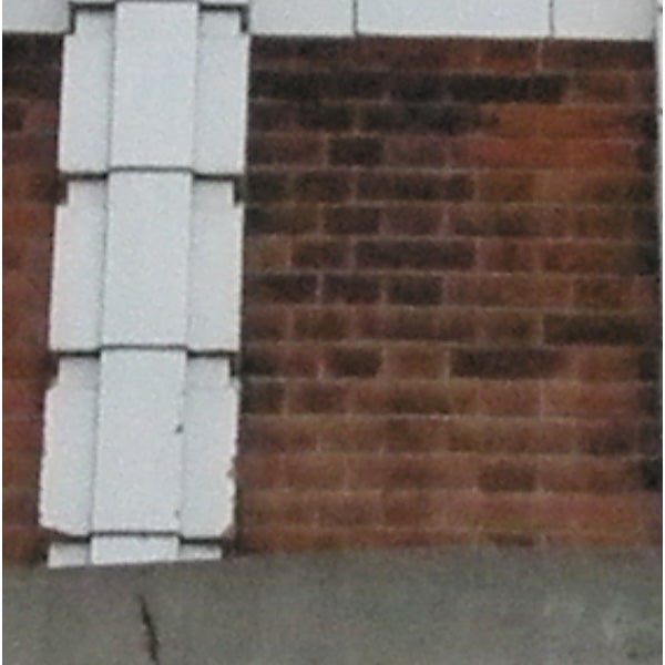 brick wall with white corner siding.Close-up photo of a brick wall with white siding taken by Olympus SP-570 UZ.