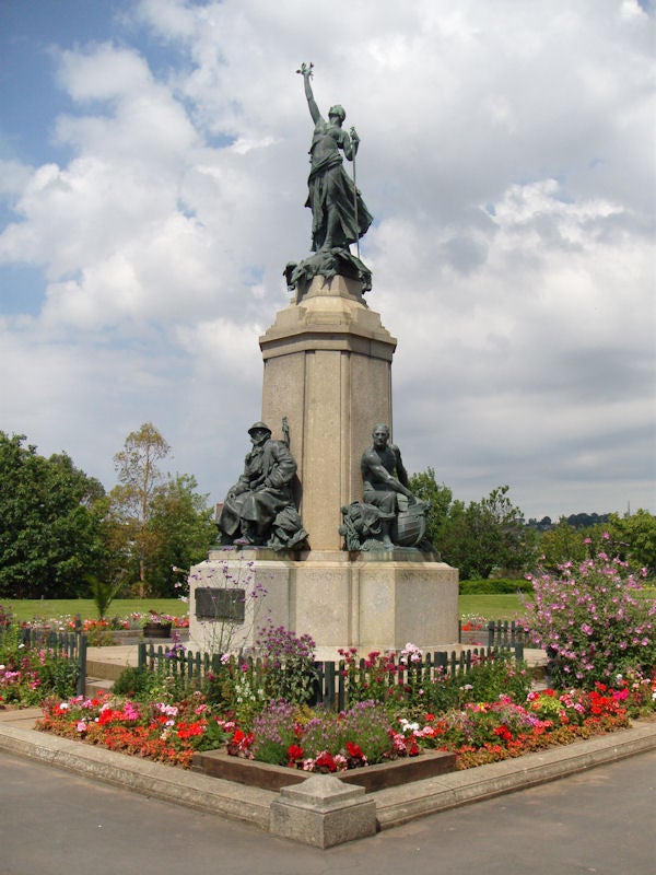 Statue surrounded by colorful flowers in a parkStatue surrounded by flowers in a park.