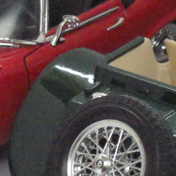 Close-up of a classic red car taken with a Samsung NV30.Close-up photo of a classic car wheel and fender.