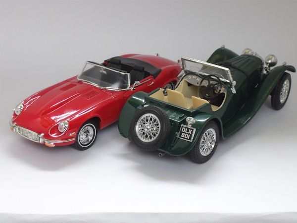Vintage red and green model cars on white background.Two model classic cars on a white background.