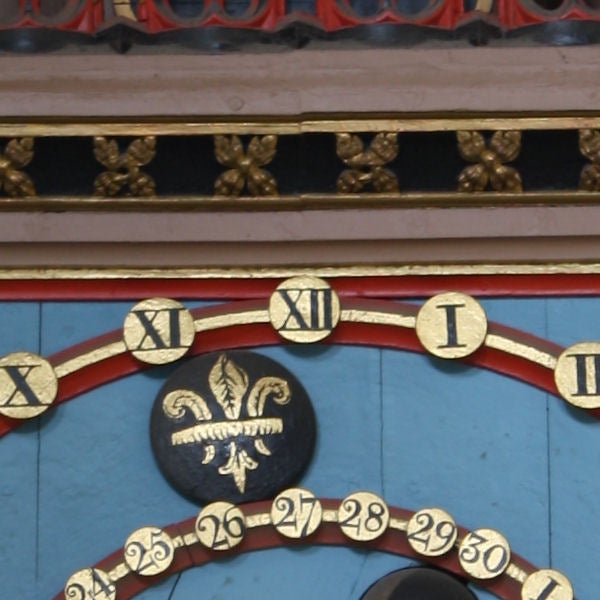 Close-up of an ornate clock face with Roman numerals.