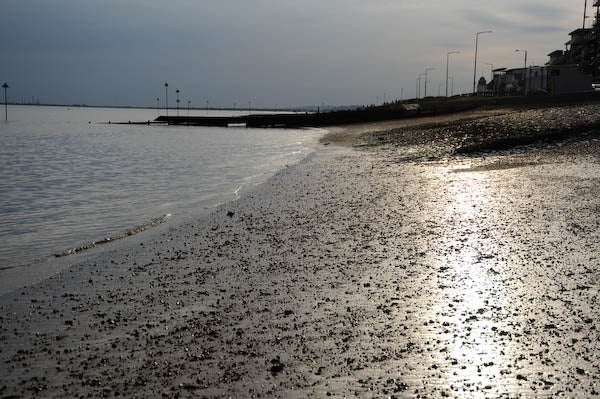 Low sun over a pebble-strewn beach taken with Nikon D700.Beach scene with shimmering water at dusk taken with Nikon D700.
