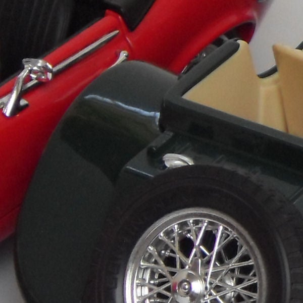 Close-up of a red vintage car model wheel and details.Close-up of a red vintage car model showing detailed wheel design.