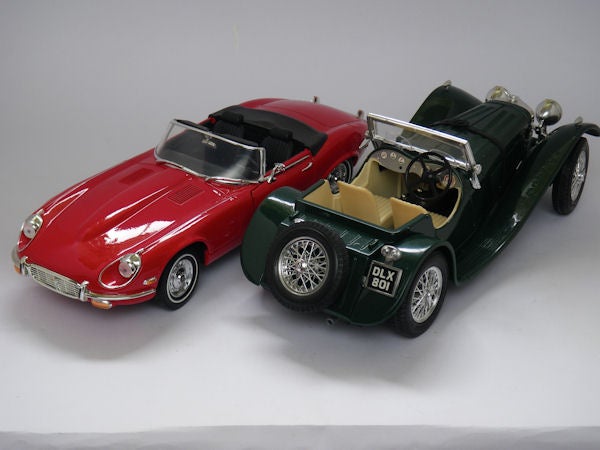 Two model cars displayed on a white background.Two model cars, a red coupe and a green sports car.