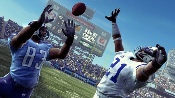 Madden NFL 09 gameplay screenshot with players reaching for football.