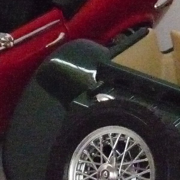 Close-up of a red vintage car wheel and fender.Close-up photo of a red car's side and wheel.