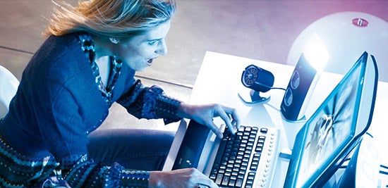Woman using computer with Philips amBX gaming peripherals.