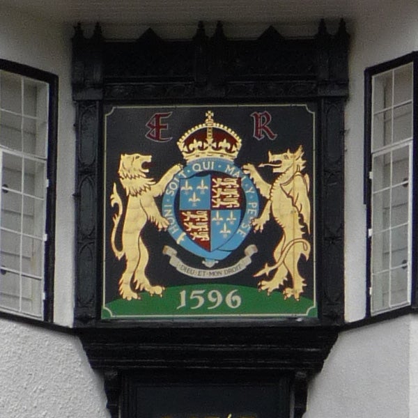 Detailed royal crest with lions and shield dated 1596.Close-up of a colorful heraldic plaque with lions and a crown.
