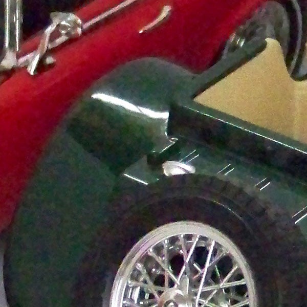 Close-up of classic red and green cars with chrome details.Close-up of a green and red vintage car model.