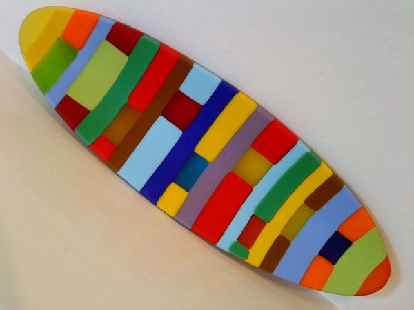 Colorful abstract pattern on a surfboard-shaped object.Colorful abstract geometric shapes on a curved surface.