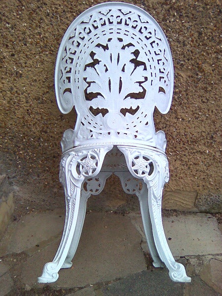 Intricately designed white metal garden chairIntricately designed white metal garden chair.