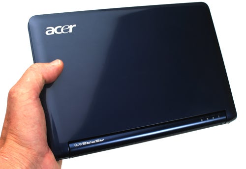 Hand holding an Acer Aspire One Netbook with logo visible.Hand holding an Acer Aspire One Netbook with a blue cover.