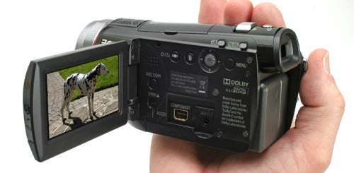 Hand holding Panasonic HDC-SD100 camcorder with screen displaying dog.Hand holding Panasonic HDC-SD100 camcorder with flip-out screen.