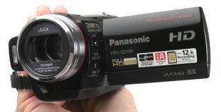 Hand holding Panasonic HDC-SD100 camcorder.