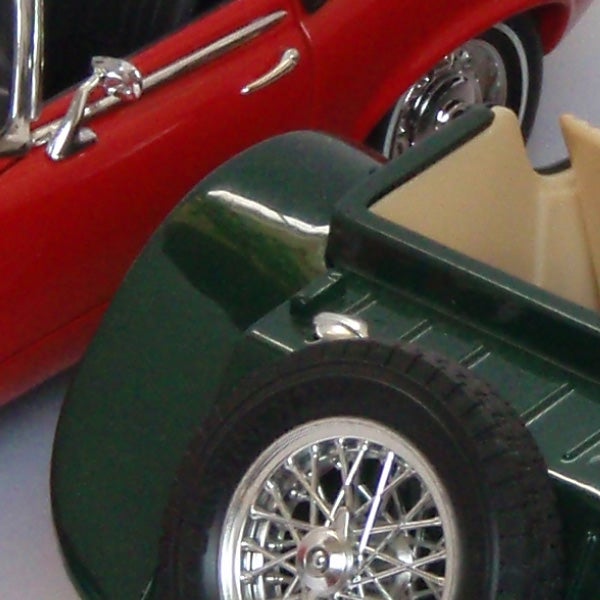 Close-up of two model cars, green and red.Close-up of two toy model cars, one red and one green