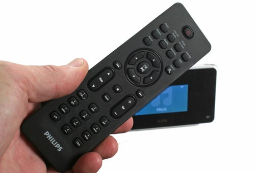 Hand holding Philips Streamium Network Music Player remote with device in background