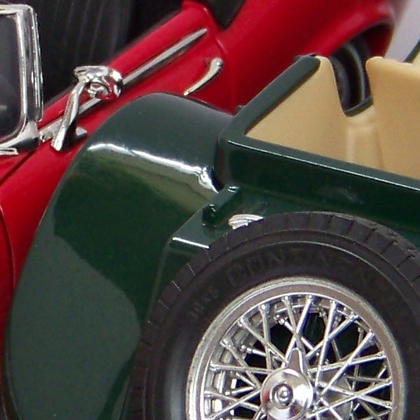 Close-up of a red and green vintage toy car wheel.Close-up of vintage red and green model car wheel and fender.