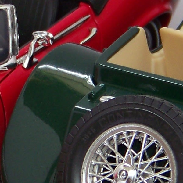 Close-up of a red and green model car with chrome details.Close-up photo of a red and green toy car.