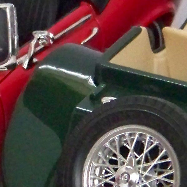 Close-up of a classic car's side and wire wheel.Close-up of a vintage car captured with Kodak EasyShare Z8612 IS.