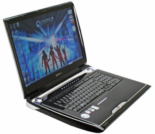 Toshiba Qosmio G50-115 notebook open on desk.Toshiba Qosmio G50-115 laptop open with screen displaying wallpaper.