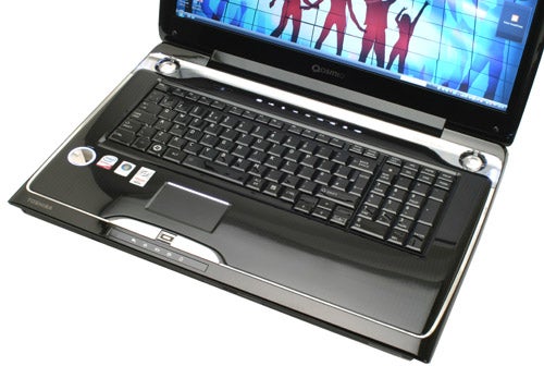 Toshiba Qosmio G50-115 laptop open on desk.Toshiba Qosmio G50-115 notebook with open screen displaying graphics.