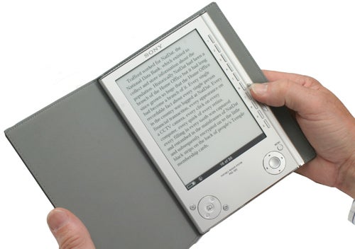 Hand holding Sony Reader PRS-505 with cover open.
